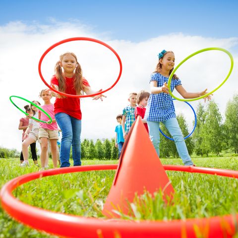kids throw colorful hoops on cones while competing