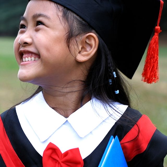 young child smiling in graduation cap and gown