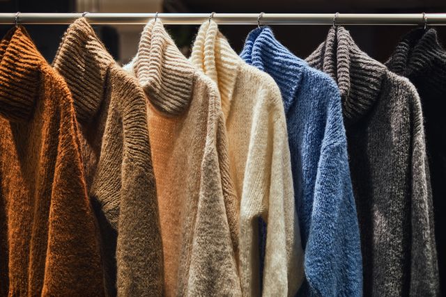 knitted winter pullovers on a rack