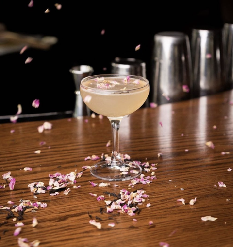 drink with flower petals falling around