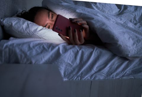 lady messaging on smartphone in bed