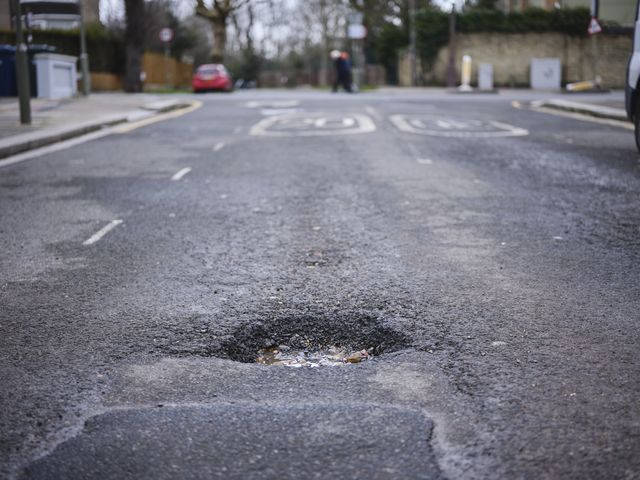 a large pot hole on residential street in north london