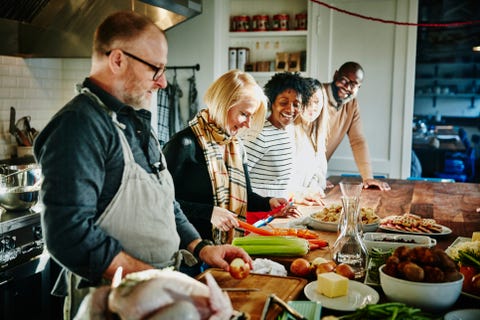 Laughing friends taking cooking class in commercial kitchen