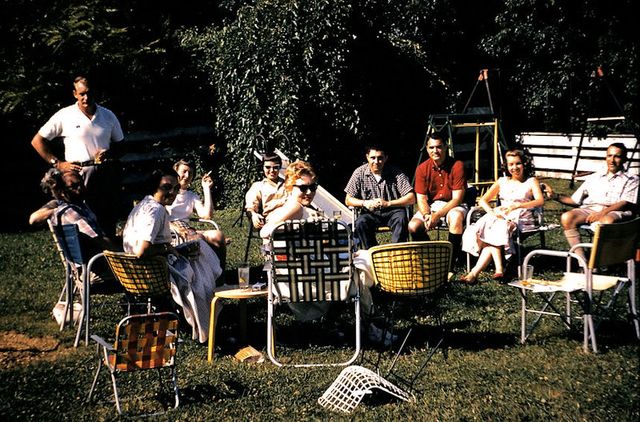 gathering of people in a yard sitting in vintage lawn chairs