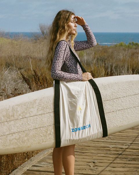 woman looking into the distance using zonarch le board bag to carry her surfboard