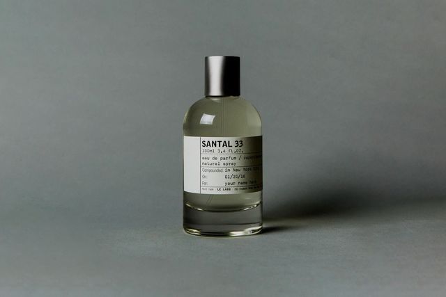 a bottle of le labo santal 33 on a dark grey background