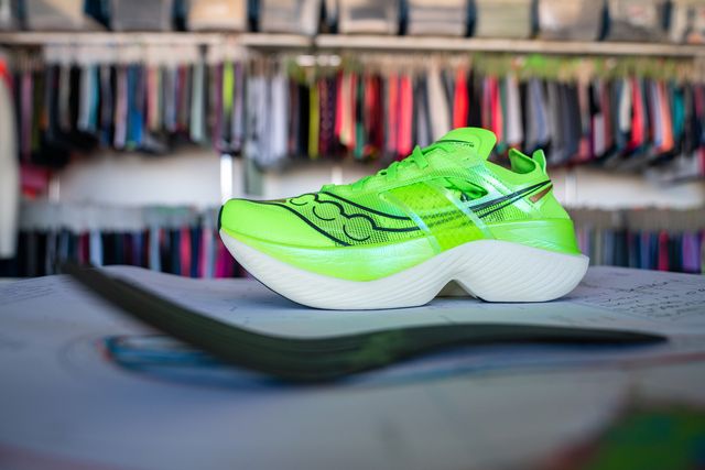 saucony endorphin elite running shoes in lime green sitting on a drafting table