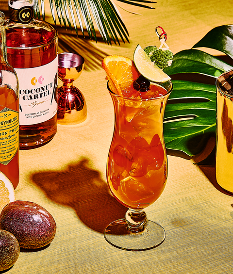 hurricane cocktail with dark rum, passion fruit, fresh lemon juice, orange slices, lime slices and maraschino cherries