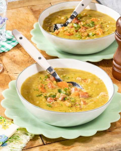 split pea soup with ham in white bowls with white spoons