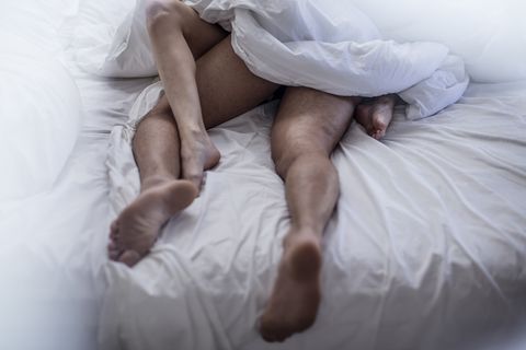 Legs of couple having sex in bed