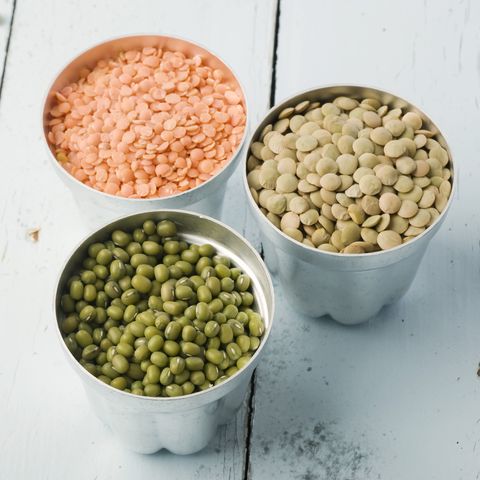 lentils and mung beans in canisters on a wooden backdrop