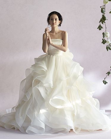 ボリュームのあるフリルのドレスを着たモデルの写真。
