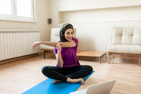 let's burn that belly fat with a home workout session a muslim woman is doing yoga at home with online help