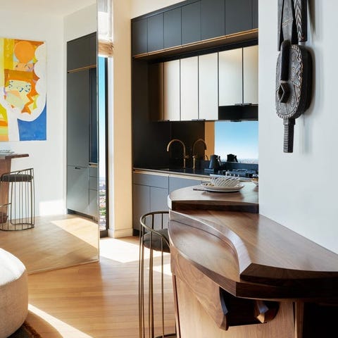 view into a sleek black kitchen and wooden counter built into the wall