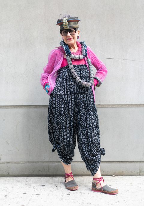 an older white woman in a hot pink jacket and patterned overalls