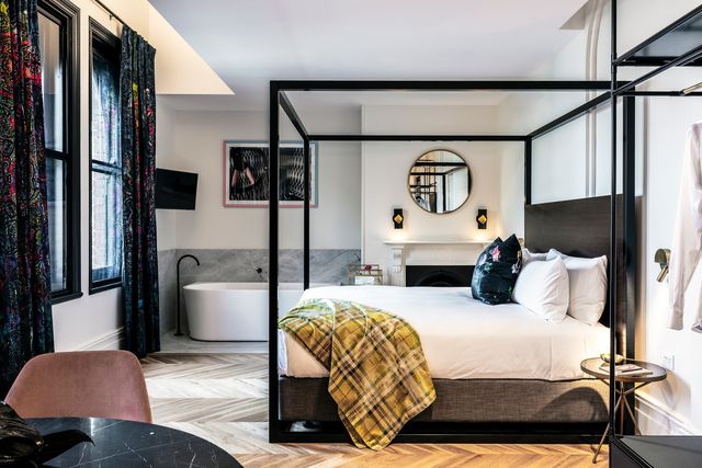 habitación negra y blanca con cama doble y dosel en el hotel little albion en sídney