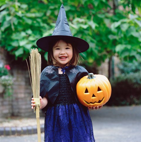 girl dressed as witch, holding pumpkin and broom, portrait