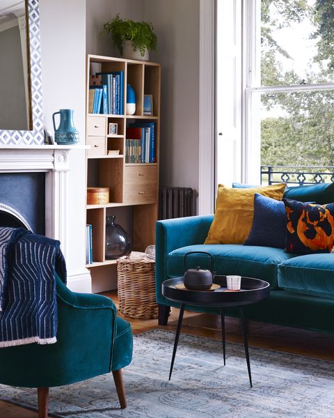 living room deep and dramatic blue hues can sometimes feel overpowering, but soft neutral walls keep the look light and airy add contemporary warm toned wood furniture for a snug, inviting spacewalls painted in mortar absolute matt emulsion, £42 for 25l, little greene izzy sofa in deep turquoise pure cotton matt velvet, £1,640, sofacom cushions l r sueda, £100, habitat islington in navy, £55 velvet paint by one nine eight five, £85 both heal’s shown on cover frame cushion cover, £75, the conran shop percy armchair in deep turquoise pure cotton matt velvet, £790, sofacom furrow throw, £159, heal’s shown on cover everyday wool throw in caramel, £495, the conran shop banyan mirror, £325, loaf jug, £75, i  jl brown monarch rug, £1,495 oak shelving unit, £795 both graham  green bowl table by ayush kasliwal for mater, £399, heal’s cast iron kettle, £145 arita tea cup, £18 oak bowl, £46 all native  co log basket, find similar at garden tradingon shelving unit abaya blue and white vase, £15 esterban glass vase, £30 both habitat gold frame, £1650, oliver bonas block alarm clock, £59, the conran shop round shaker box, £34192 for five, james morgan at selvedge