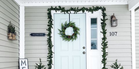 a front porch entrance with christmas decor and snow
