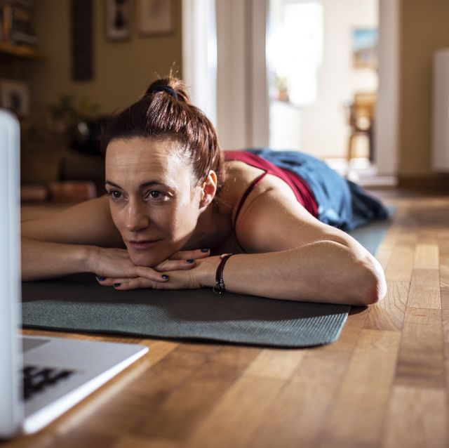 Young woman using a laptop while doing yoga