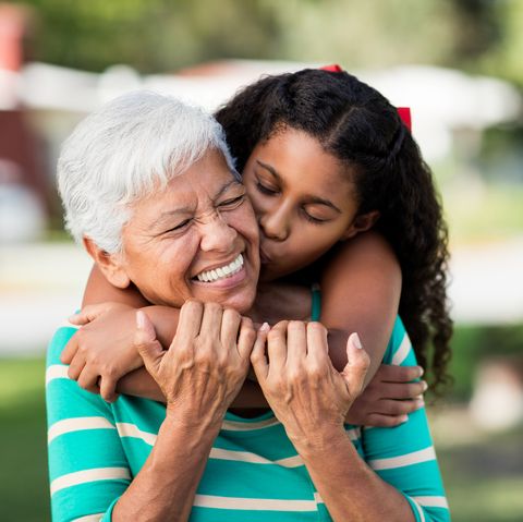 Loving teen girl embracing and kissing grandmother