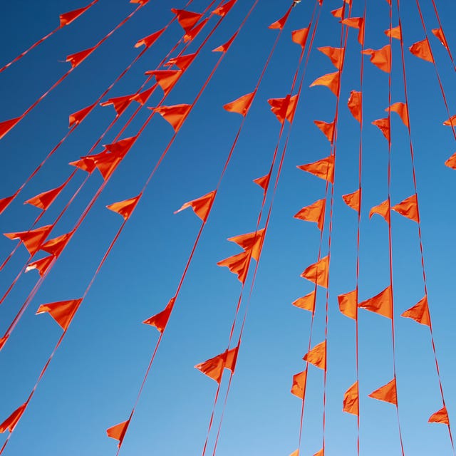Low Angle View Of Orange Buntings Against Clear Blue Sky low angle view of orange buntings against clear blue sky