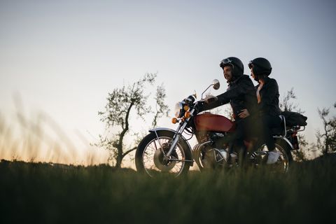 low angle view of young couple on motorcycle against clear sky