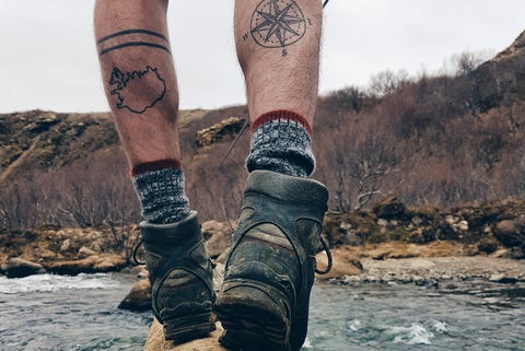 low section of man balancing on log over river