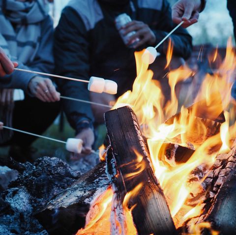 low section of people having marshmallows on barbecue