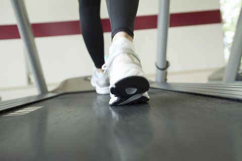 Low section of woman exercising on treadmill