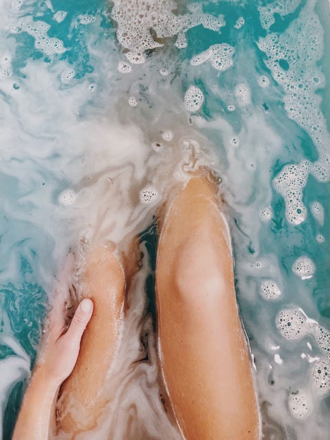 Low Section Of Woman Legs Sitting In Bathtub