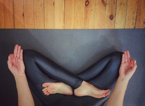 Low Section Of Woman Meditating At Home