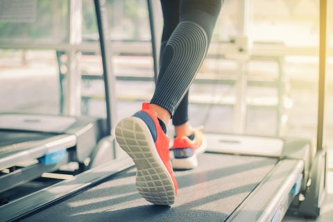 Low Section Of Woman Running On Treadmill In Gym