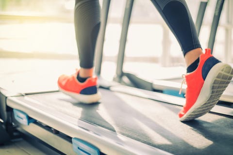 Low Section Of Woman Running On Treadmill In Gym