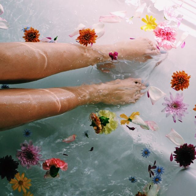 low section of woman with flowers in water