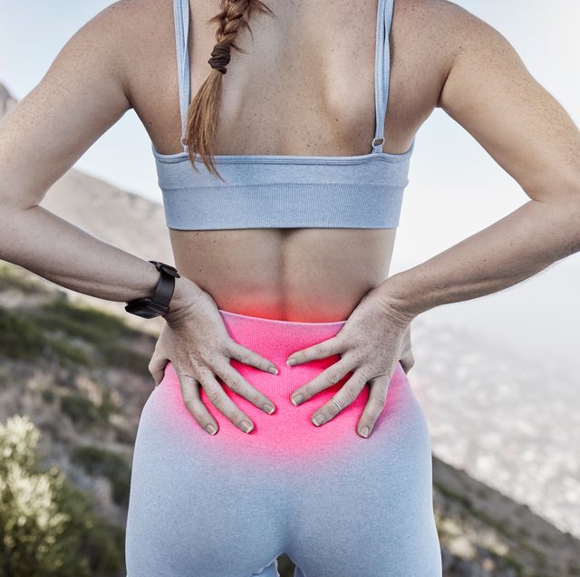 lower back pain, sports injury and woman holding sore body part after training, exercise and workout with glowing red sportswear runner, sports female and athlete outside for fitness and relief