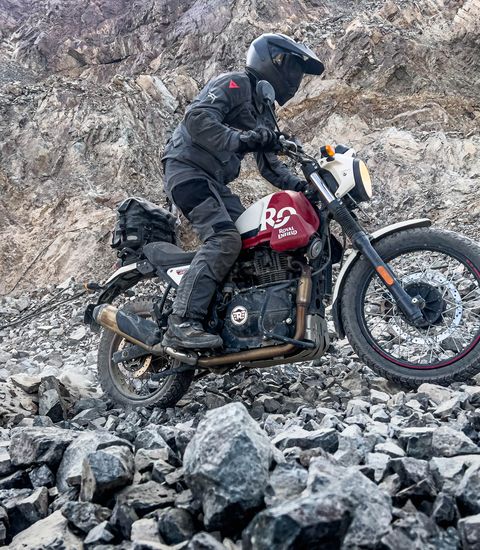 a person riding a motorcycle over rocks