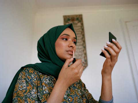 portrait of young woman applying make up
