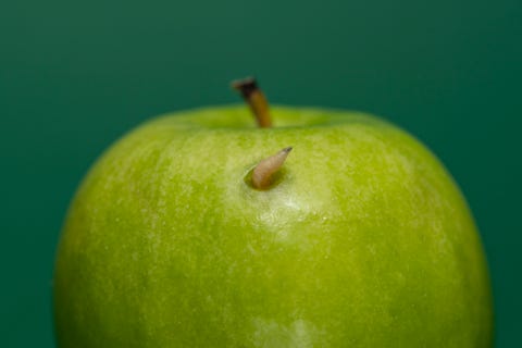 Maggot poking out of a green apple