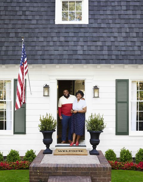 makeover takeover exterior with couple standing in doorway