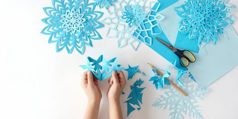 Making of snowflakes from blue paper.
