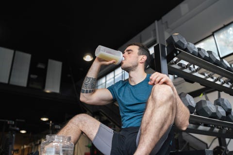Male athlete drinking protein shake while sitting in gym male athlete drinking protein shake while sitting in gym