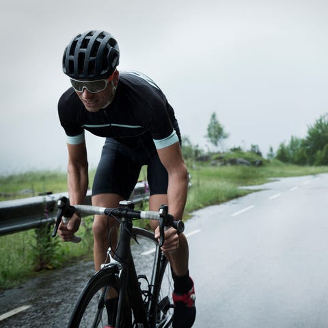 Male race cyclist driving up mountain road Male race cyclist driving up mountain road