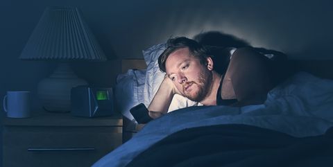 Male using Smartphone in Bed at Night