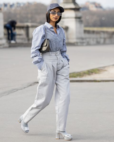 vrouw in grijs beige outfit met pet paris fashion week