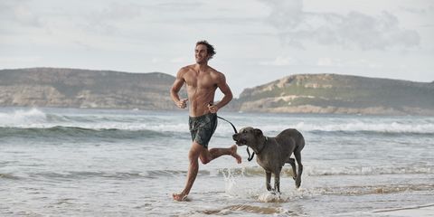 Man and dog running on beach