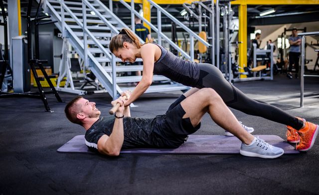 man and woman working out at the gym