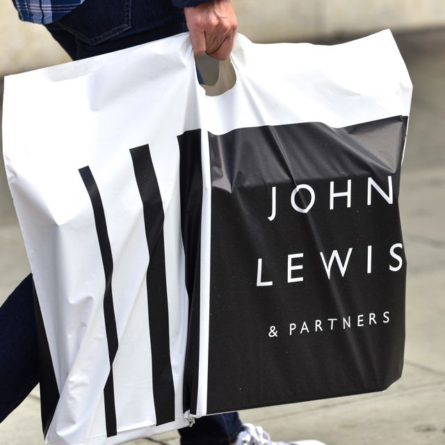 a man carrying a john lewis and partners shopping bag at