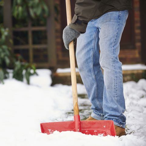 Man Clearing Snow From Path With Shovel