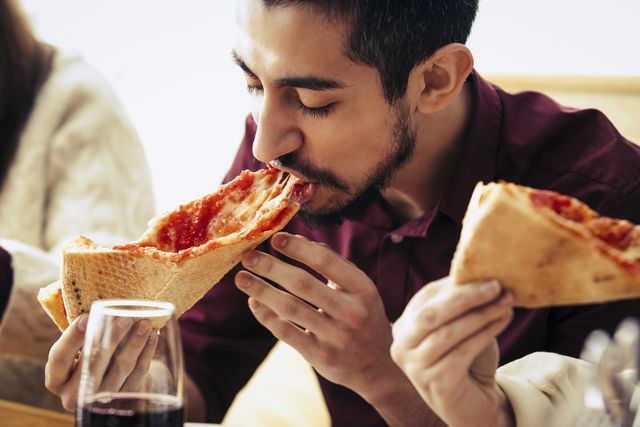 man eating a slice of pizza